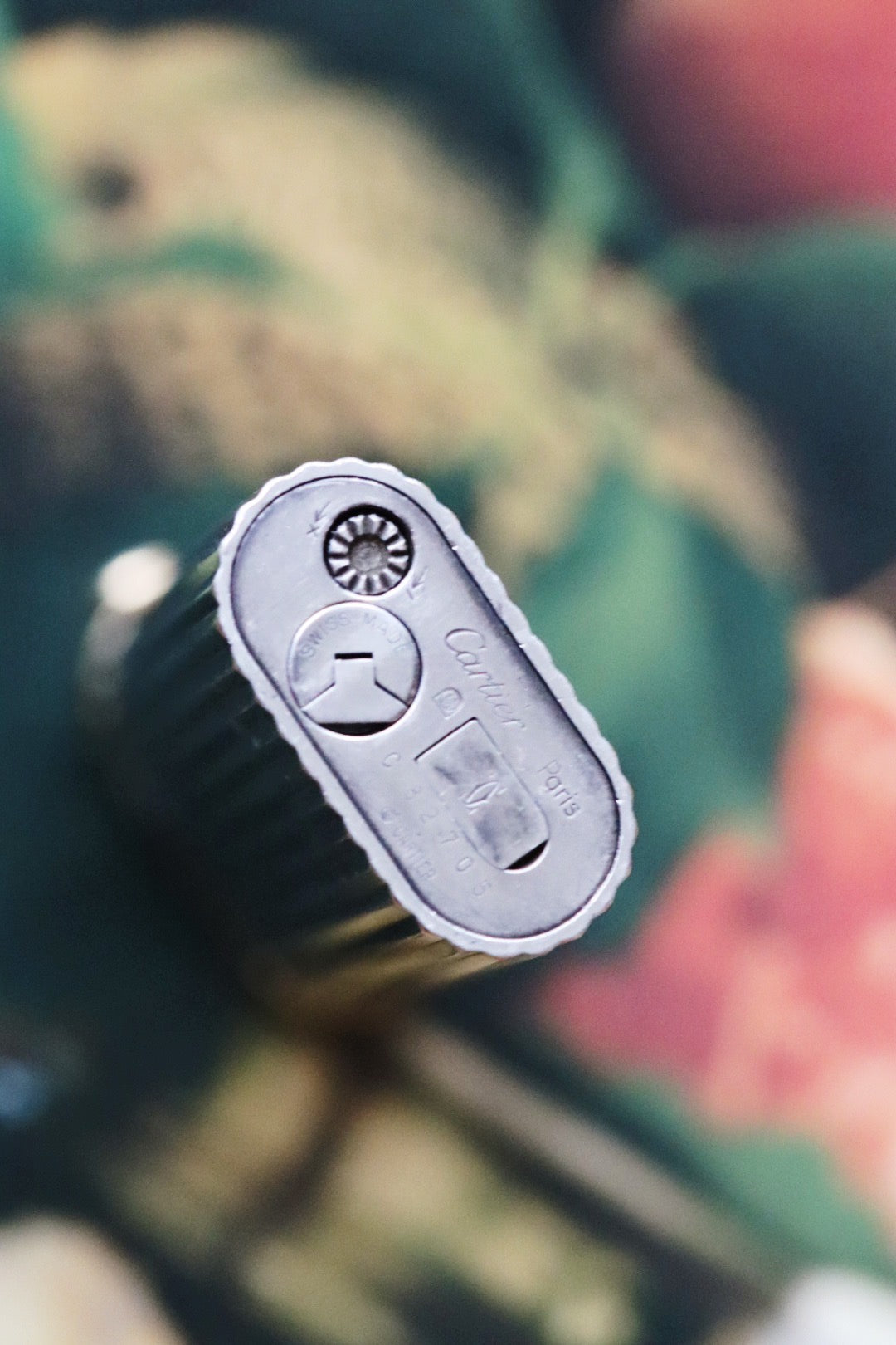 Cartier lighter with a ribbed silver finish and a blue cabochon.