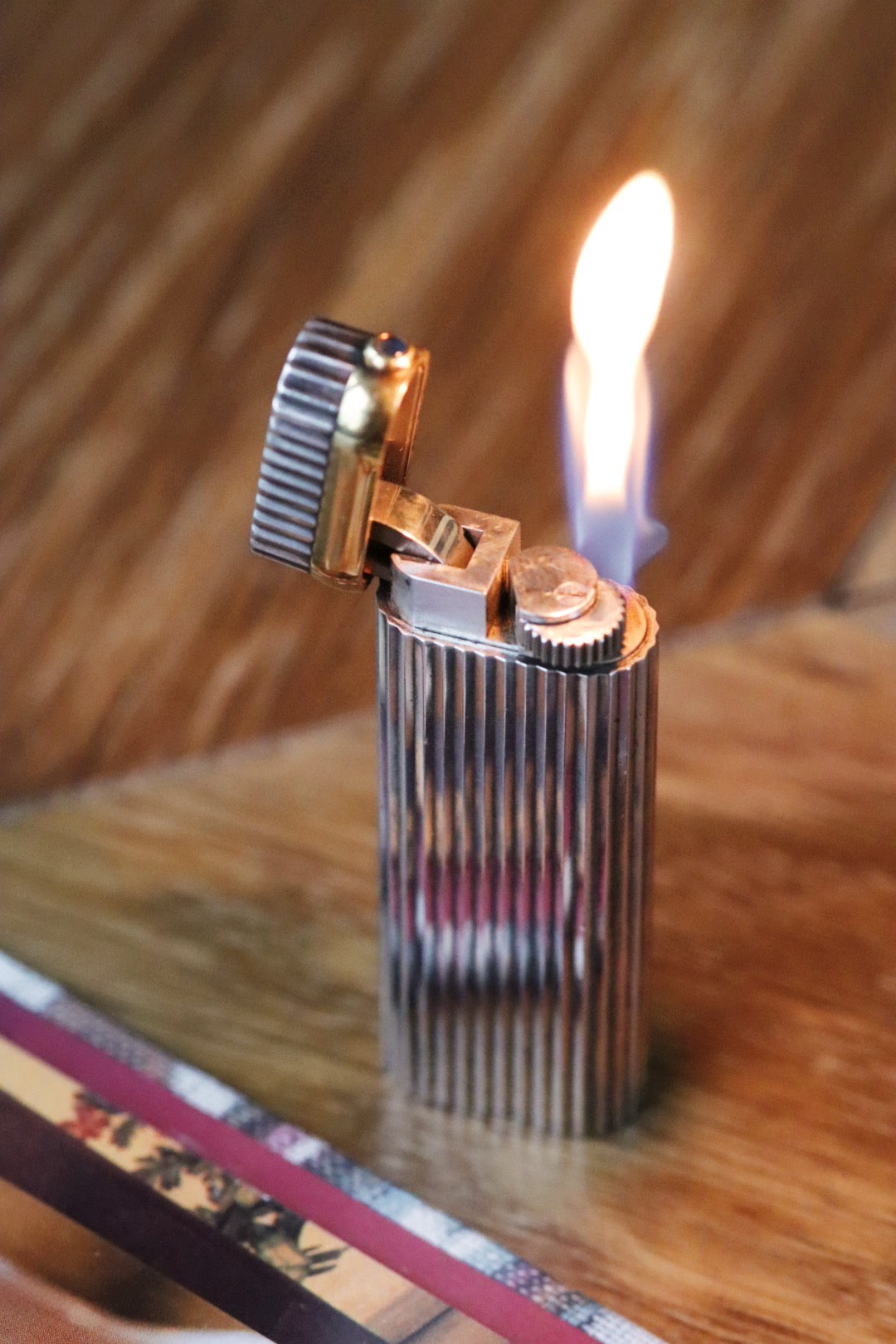 Cartier lighter with a ribbed silver finish and a blue cabochon.