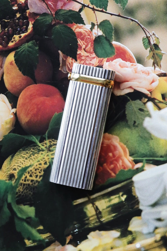 Cartier lighter with a ribbed silver finish and a blue cabochon.